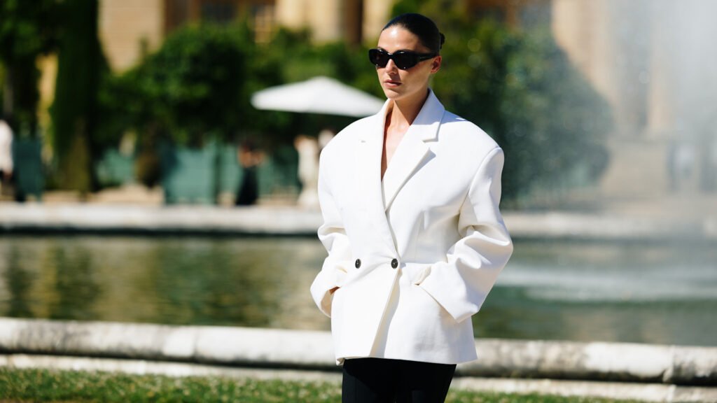 A paris fashion week attending wearing sunglasses and white oversized blazer