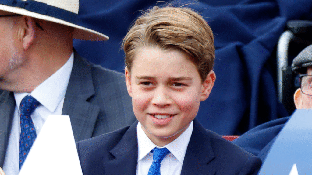 Prince George smiling in a blue suit and tie