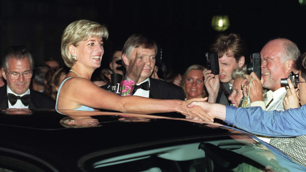 Princess Diana sticking her head out of a limo sunroof and shaking hands with fans in 1997