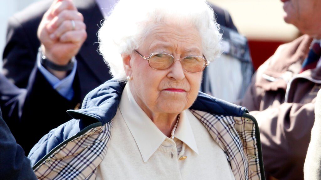 Queen Elizabeth II has pursed lips and white hair and looks very annoyed