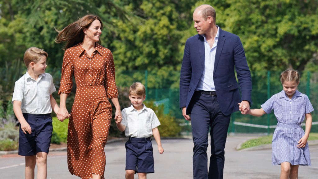 Prince George, Kate Middleton, Prince Louis and Princess Charlotte holding hands in a line with their parents walking to school