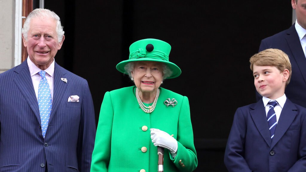 King Charles, Queen Elizabeth wearing bright green, and Prince George stand on the Buckingham Palace balcony