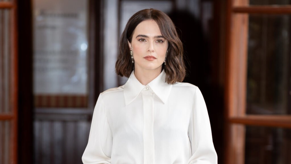 Zoey Deutch’s Lob Hairstyle Is Reimagining Airport Hair Zoey Deutch wearing a white button up shirt